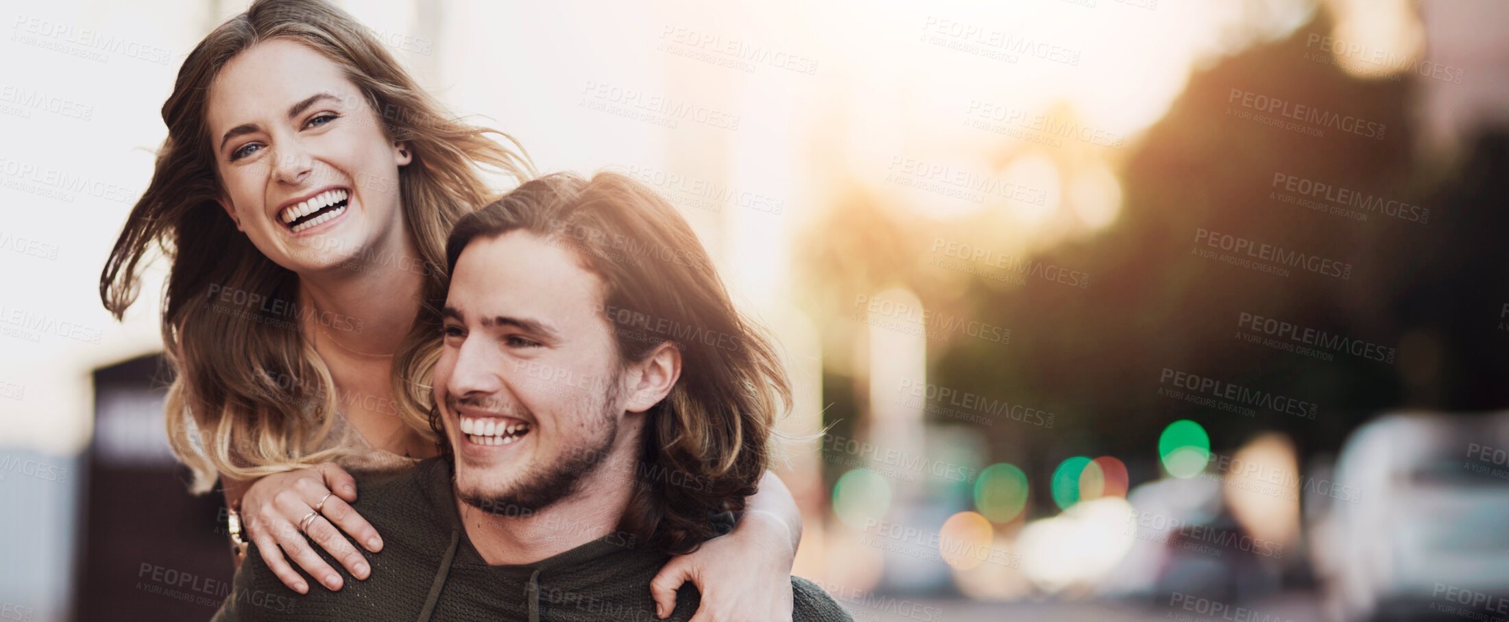 Buy stock photo Portrait of a happy young couple enjoying a piggyback ride in the city