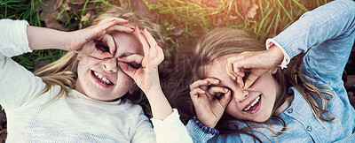 Buy stock photo Portrait of two little sisters lying on the grass outside