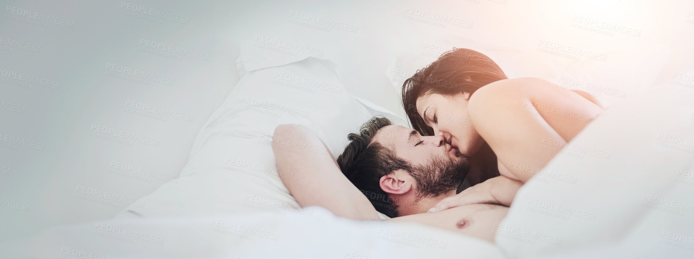 Buy stock photo Shot of an affectionate couple lying on their bed