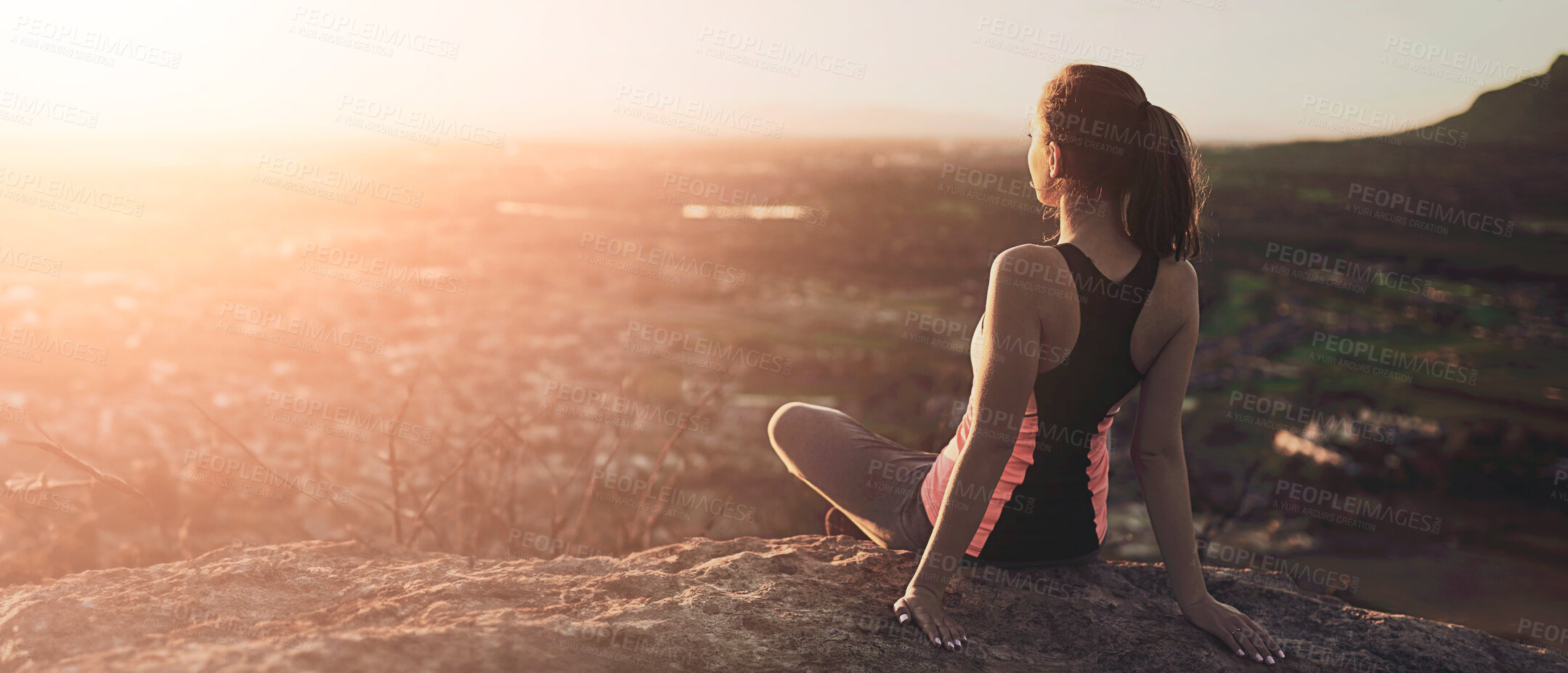 Buy stock photo Rearview shot of a sporty young woman taking in the view during a hike up the mountain