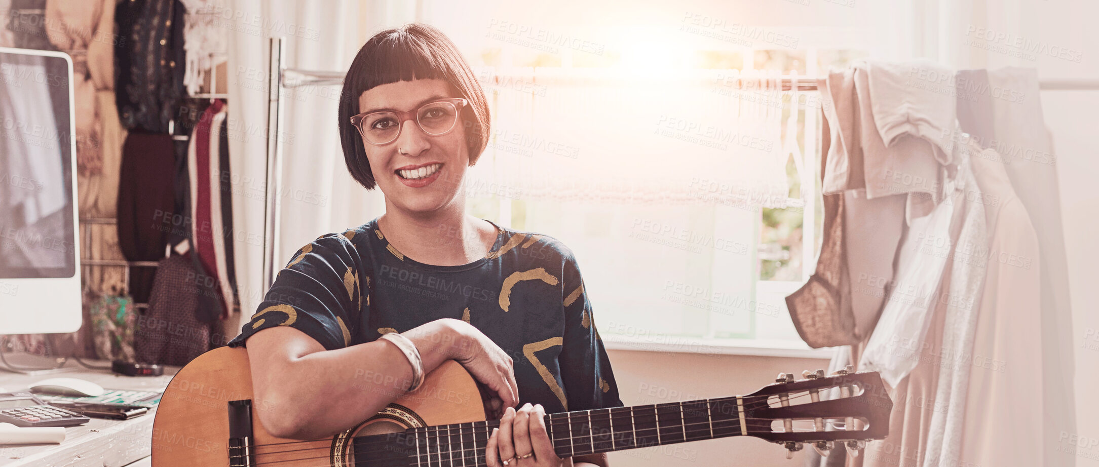 Buy stock photo Portrait of a stylish young woman sitting in her eclectic toom playing a guitar