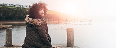 Buy stock photo Portrait of a young woman looking over her shoulder while sitting on a pier