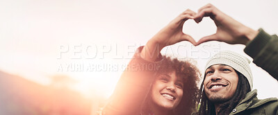 Buy stock photo Shot of two friends making a heart shape with their hands while standing outside