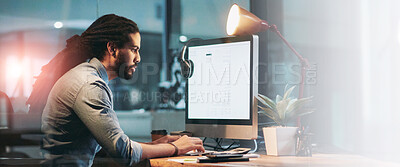 Buy stock photo Shot of a young designer working late on a computer in an office