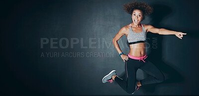 Buy stock photo Shot of a sporty young woman jumping against a grey background