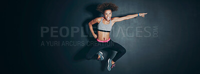 Buy stock photo Shot of a sporty young woman jumping against a grey background