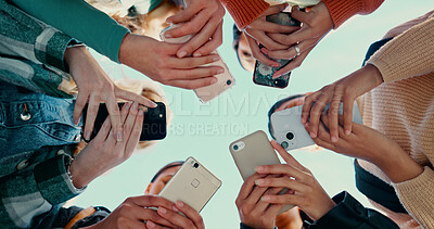 Buy stock photo Outdoor, people hands with smartphone for connection, networking and share information for location. Group, friends and solidarity with cellphone for mobile app, download or social media by low angle