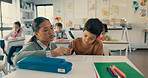 Help, teacher and kid at desk in classroom with notebook, growth and child development in education. Learning, woman and boy student together with support, writing and exam notes at elementary