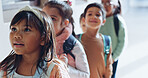 Education, students and children in row outdoor for lesson, learning and back to school. Kids, girl and waiting in line by classroom with backpack for scholarship, ready for knowledge and studying