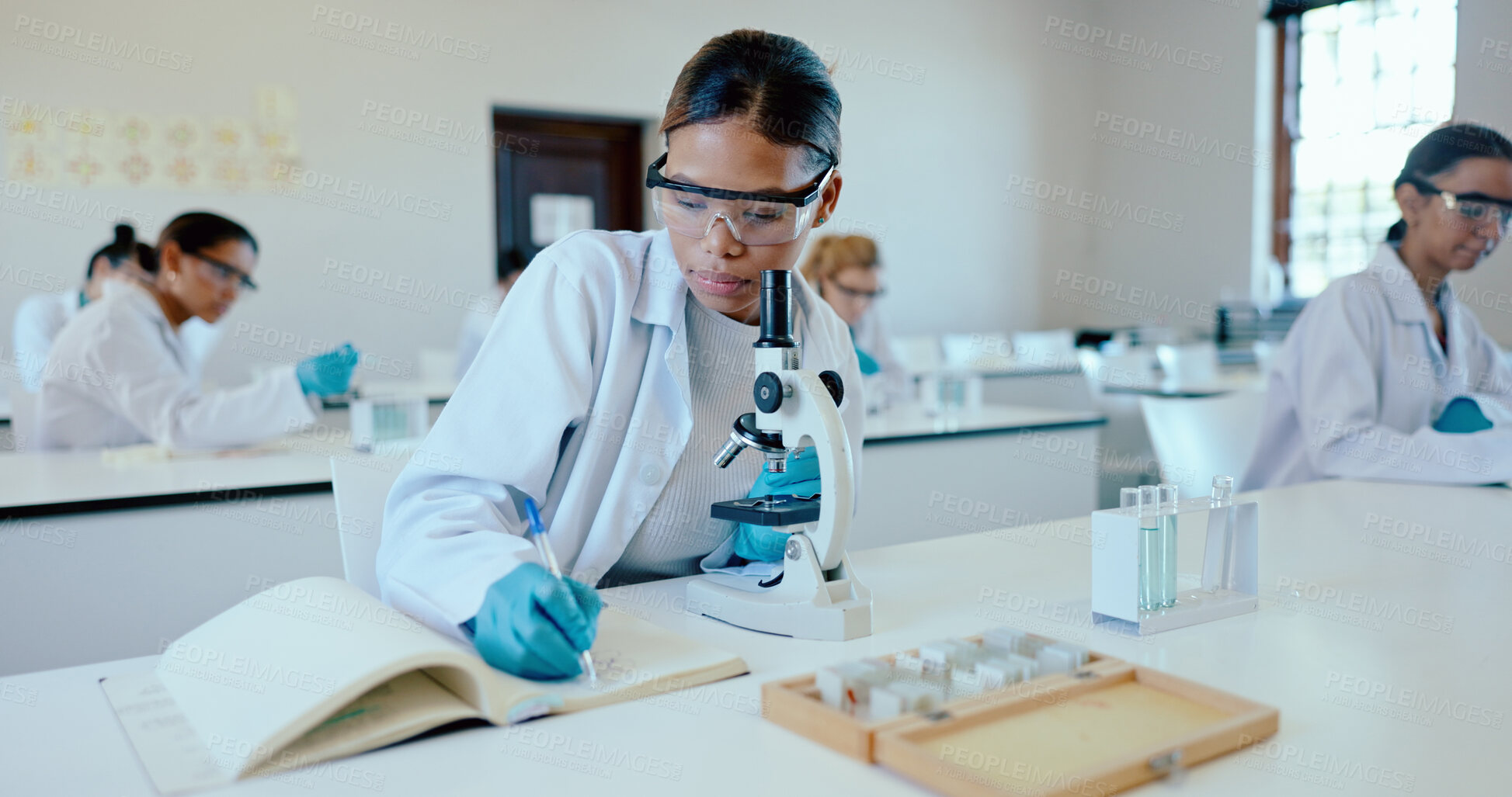 Buy stock photo Writing, student and microscope in science classroom for chemistry analysis, sample study and practical lesson notes. High school, girl or results of medical research for education with safety in lab