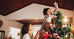 Christmas, decoration and love with family and tree for festive magic, Noel cheer and xmas celebration. Star, winter holiday and tradition with people at home for present, vacation and helping