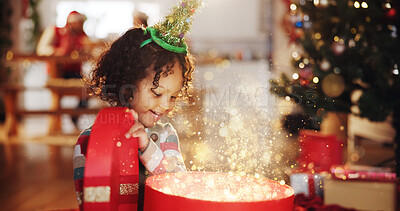 Buy stock photo Christmas, glitter and magic with child and gift for festive, Noel cheer and xmas celebration. Happiness, winter holiday and surprise with girl and box in home for present, vacation or creative