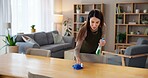 Woman, disinfectant and wipe table in home for cleaning service, housekeeping and remove dust. Cleaner, person and chemical spray for dirty surface, germs prevention or bacteria with hygiene in house