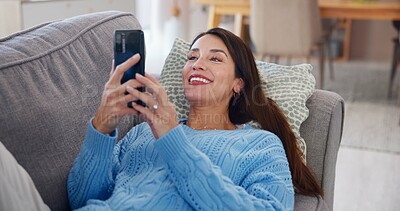 Buy stock photo Woman, phone and relax on sofa in home with social media post, streaming subscription and online videos. Person, happy and smartphone on couch for reading ebook, dating site or browsing internet blog