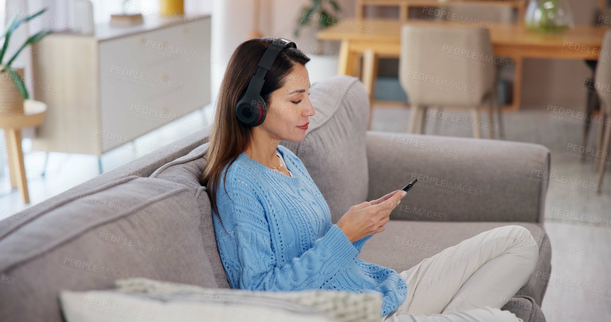 Buy stock photo Woman, relax and phone with headphones on sofa for online, streaming or listening to audio at home. Calm, sound and female person with tech in living room for mindfulness, podcast or peace on weekend