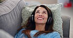 Happy, woman and relax with headphones on sofa for online, streaming and listening to audio at home. Lay, smile and female person with tech in living room for mindfulness, podcast or peace on weekend