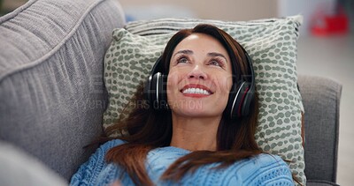 Buy stock photo Happy, woman and relax with headphones on sofa for online, streaming and listening to audio at home. Lay, smile and female person with tech in living room for mindfulness, podcast or peace on weekend