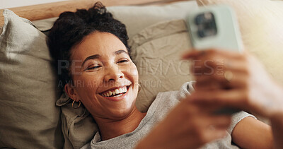 Buy stock photo Woman, laughing and phone on bed for internet surfing in home, typing message and notification. Female person, bedroom and online for communication, reading funny ebook and weekend in apartment