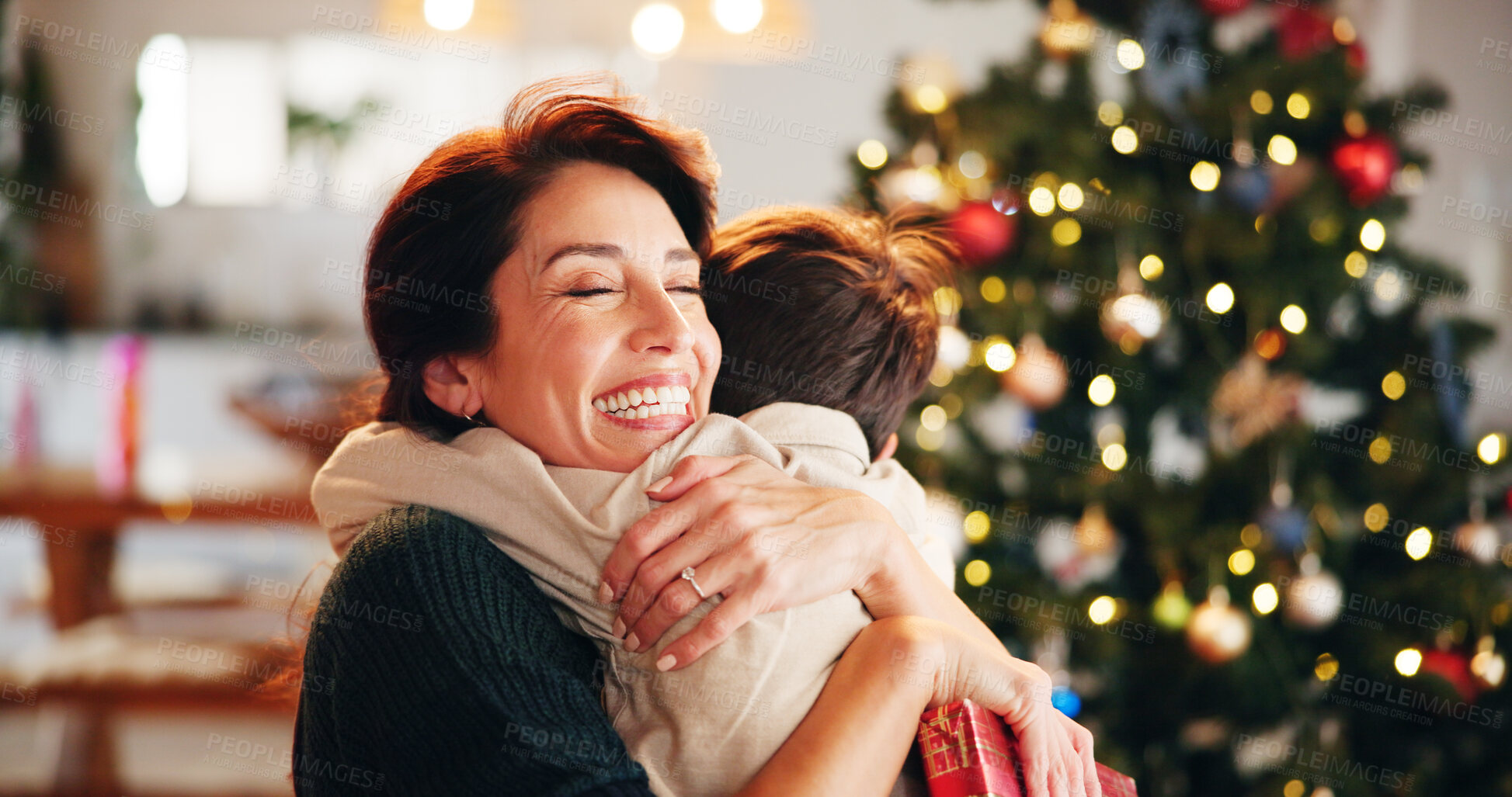 Buy stock photo Christmas, house and hug with mother, son and bonding together with gift, decoration and care in lounge. Xmas tree, family and parent with boy, embrace and present with happiness, holiday and festive