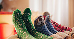 Christmas, socks and feet of family, lounge and bonding for holiday, season and celebration in home. House, legs and parents with child, living room and together for festive, relax and people