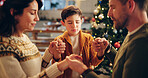 Family, praying and holding hands in home for Christmas, solidarity and gratitude with spiritual connection. Parents, boy and worship in living room for thanks, faith and vacation as Christian people