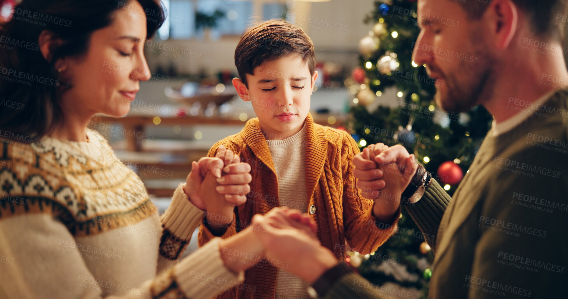 Buy stock photo Family, praying and holding hands in home for Christmas, solidarity and gratitude with spiritual connection. Parents, boy and worship in living room for thanks, faith and vacation as Christian people