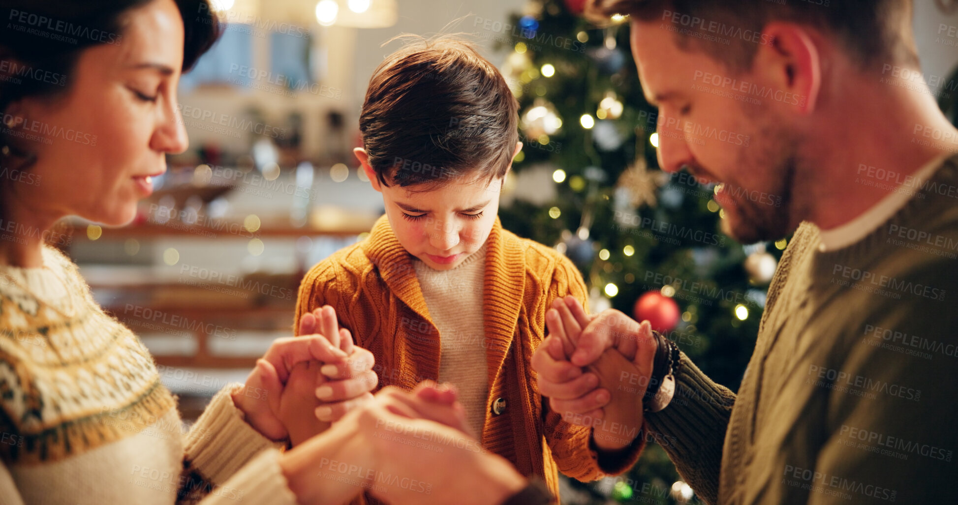 Buy stock photo Family, prayer and holding hands in house for Christmas, solidarity and gratitude with spiritual connection. Parents, boy and worship in living room for thanks, faith and vacation as Christian people