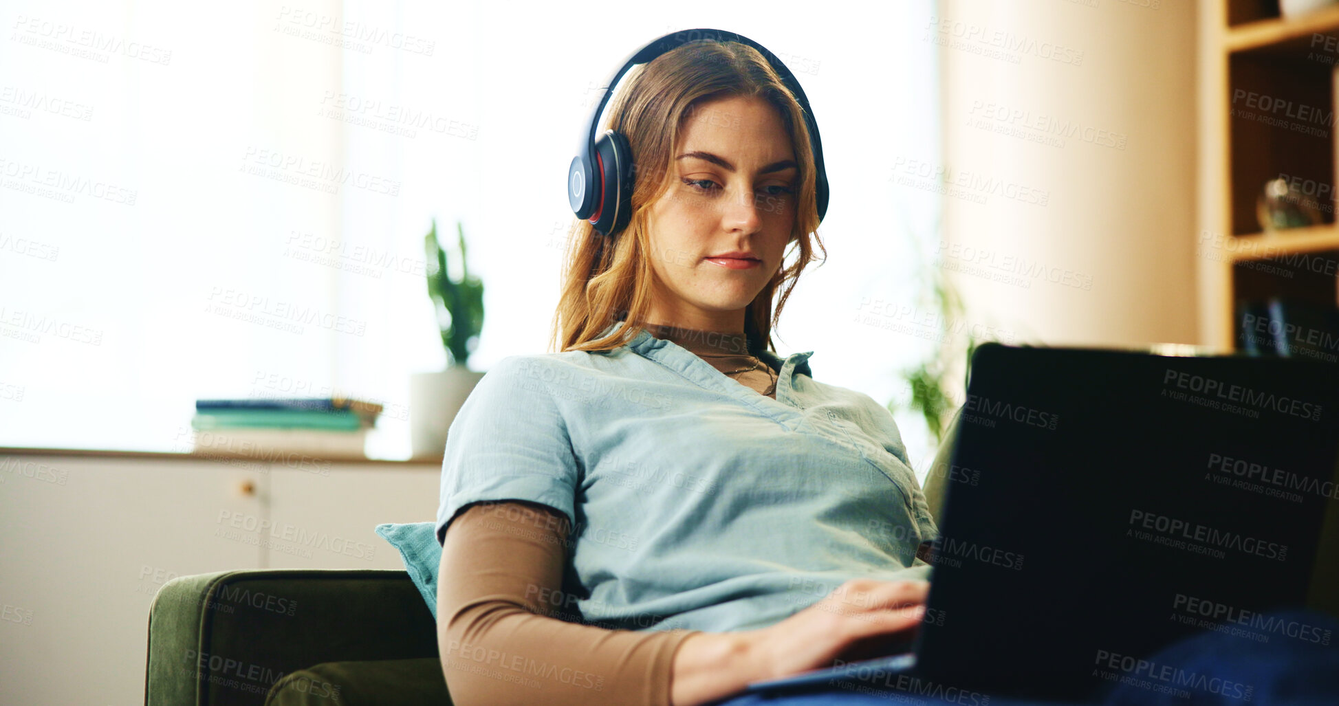 Buy stock photo Laptop, headphones and woman on sofa with online course, research or education webinar in home. Elearning, relax and student girl on couch with computer, connection or music steaming in apartment