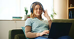 Laptop, headphones and girl on sofa with online course, comfort or listening to webinar in home. Elearning, relax and student on couch with computer, podcast connection or music streaming in lounge