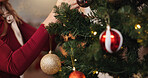 Christmas, hand and tree with person and decoration for bauble, gift giving and festive season. Xmas, holiday and celebration with closeup in living room at home for tradition, noel and winter
