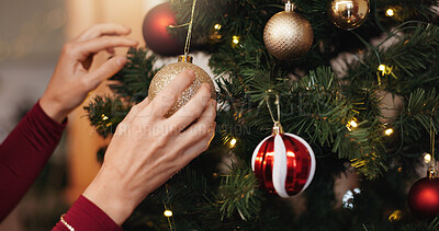 Buy stock photo Christmas, closeup and tree with person and bauble for decoration, gift giving and festive season. Xmas, holiday and celebration with hands in living room at home for tradition, noel and winter