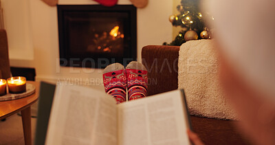 Buy stock photo Christmas, book and socks with person in living room of home for celebration, reading or relax. Break, hobby and wellness with feet at apartment fireplace for December holiday, tradition or vacation