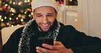 Christmas, home and man with smartphone, typing and smile for social media, digital app and festive. Happy person, Xmas and guy in lounge, cellphone or online chatting with contact, app or connection