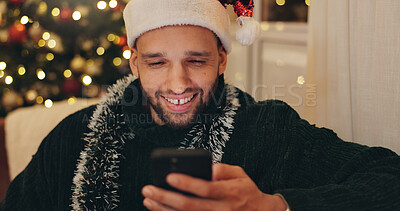 Buy stock photo Christmas, home and man with smartphone, typing and smile for social media, digital app and festive. Happy person, Xmas and guy in lounge, cellphone or online chatting with contact, app or connection