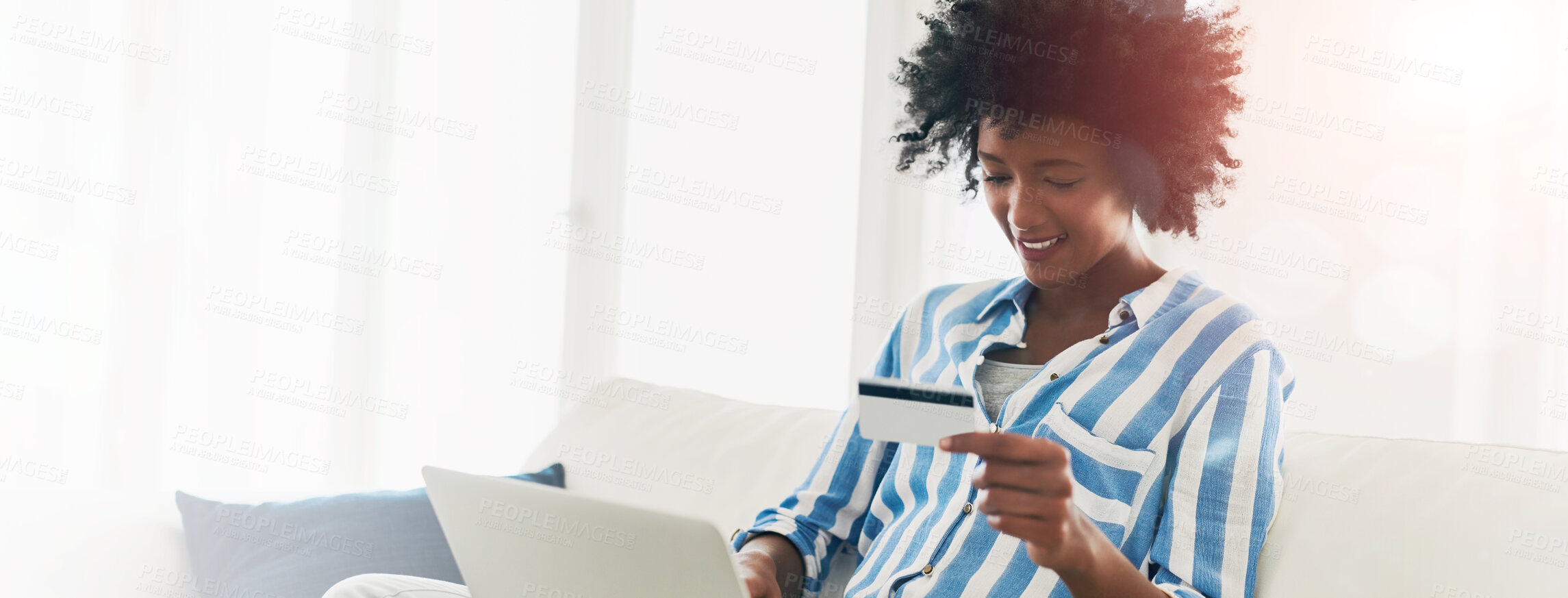 Buy stock photo Cropped shot of a young woman using a credit card to make an online payment at home