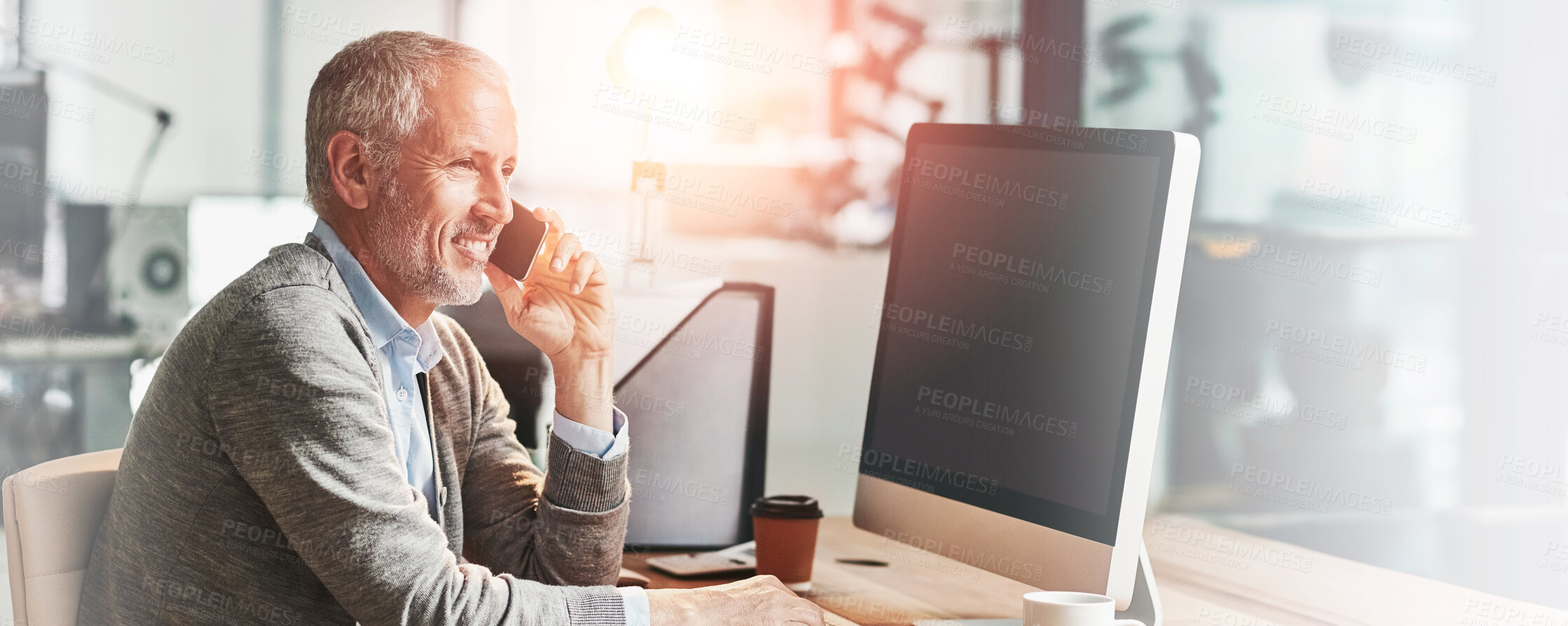 Buy stock photo Shot of a mature businessman talking on the phone while sitting at his desk in an office