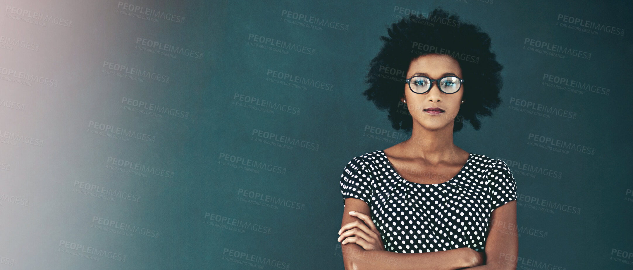 Buy stock photo Portrait of a confident young businesswoman standing with her arms folded in the studio