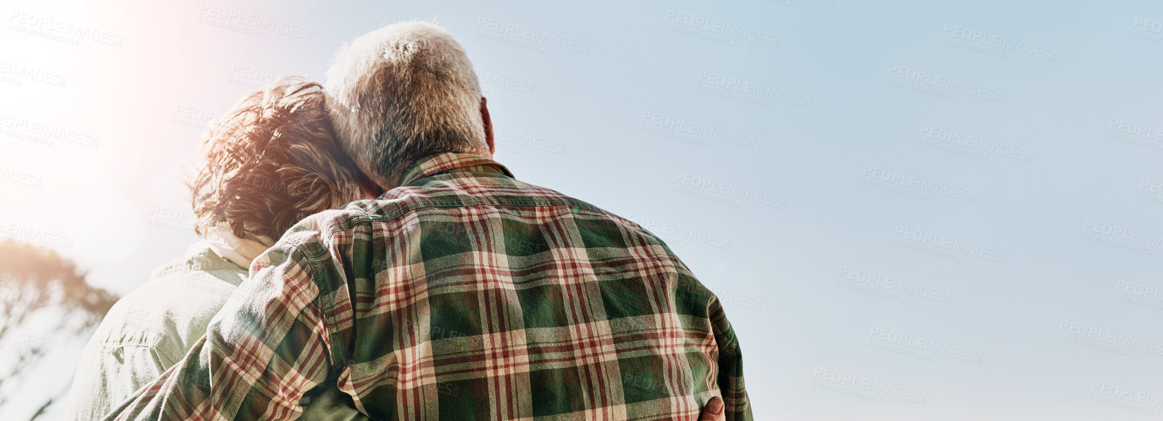 Buy stock photo Rearview shot of a senior couple embracing outside on the balcony