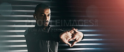 Buy stock photo Shot of an athletic young man warming up before his workout in the gym