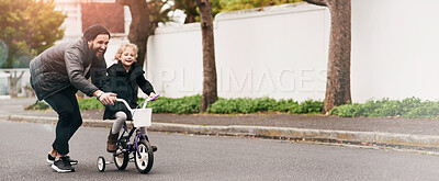 Buy stock photo Shot of a father teaching his little daughter how to ride a bicycle