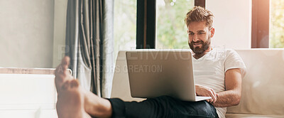 Buy stock photo Shot of a young man using a laptop at home