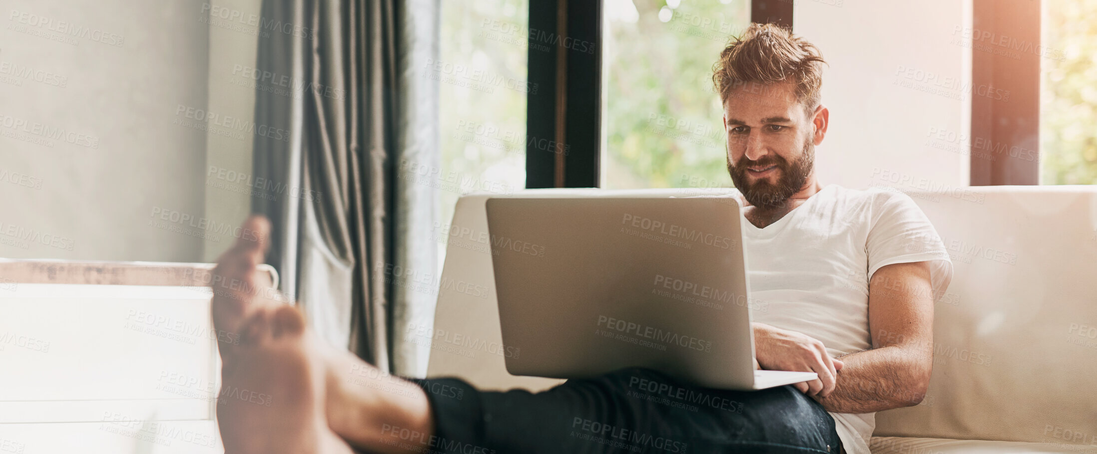 Buy stock photo Shot of a young man using a laptop at home