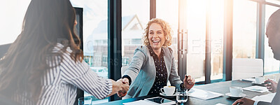 Buy stock photo Shot of two corporate businesswomen shaking hands during a meeting in the boardroom