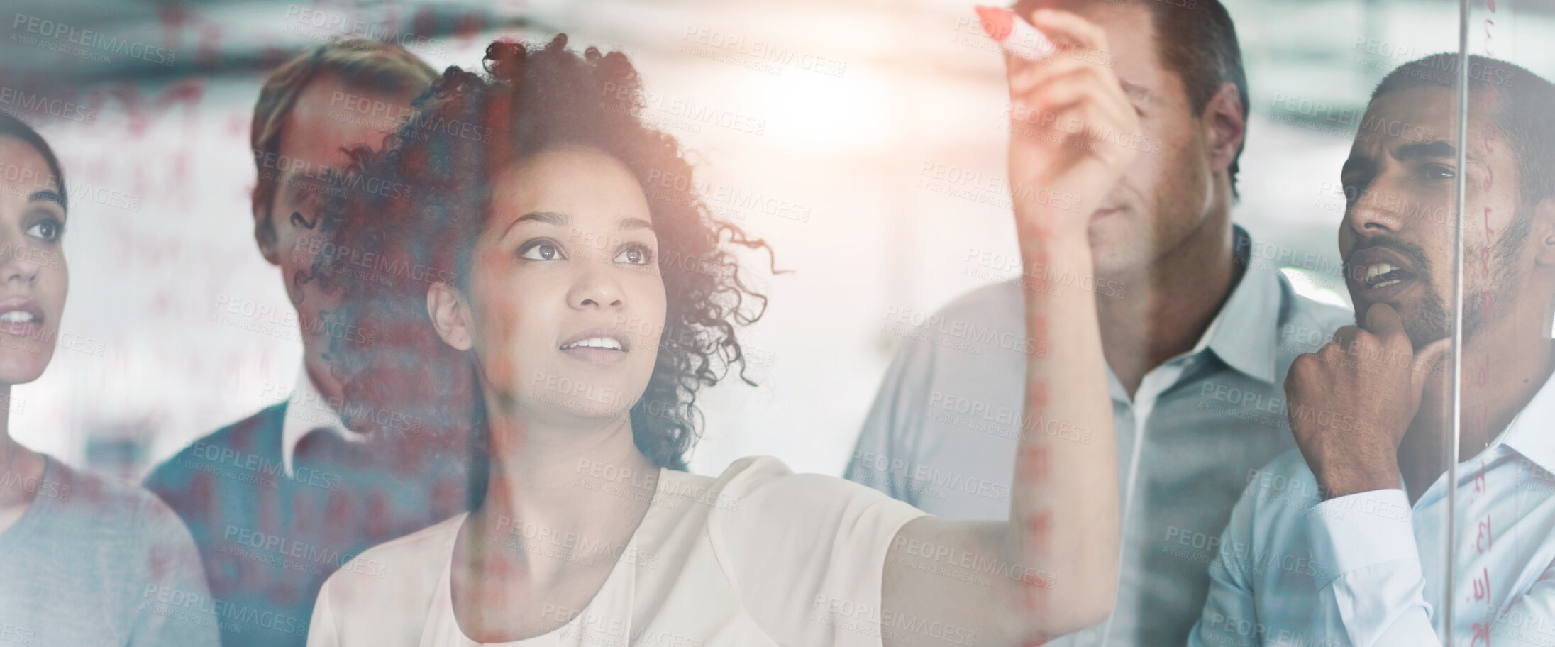 Buy stock photo Shot of a group of creative businesspeople plotting out details on a glass wall