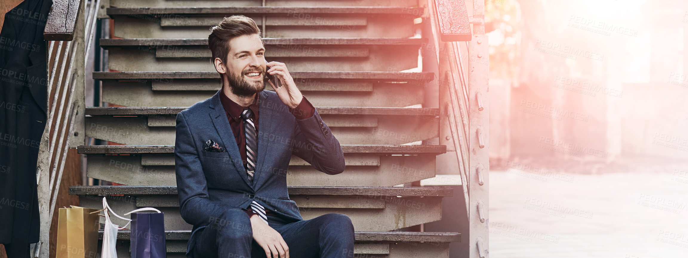 Buy stock photo Shot of a well dressed young man using his phone on a shopping spree