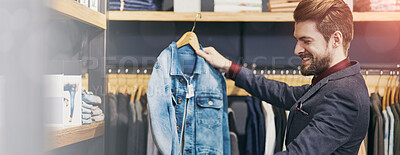 Buy stock photo Shot of a young man looking at clothes in a boutique