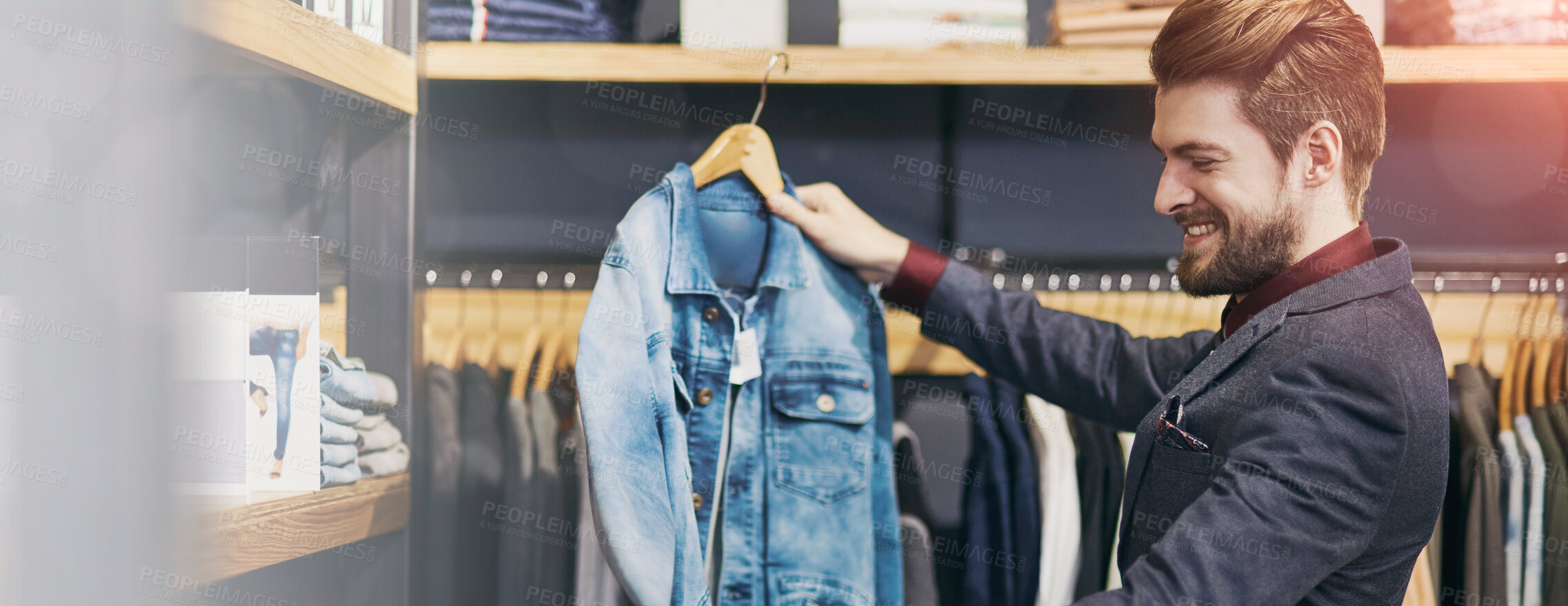 Buy stock photo Shot of a young man looking at clothes in a boutique