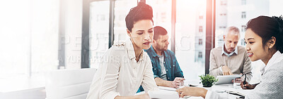 Buy stock photo Shot of two coworkers talking together over a digital tablet while sitting together in a meeting