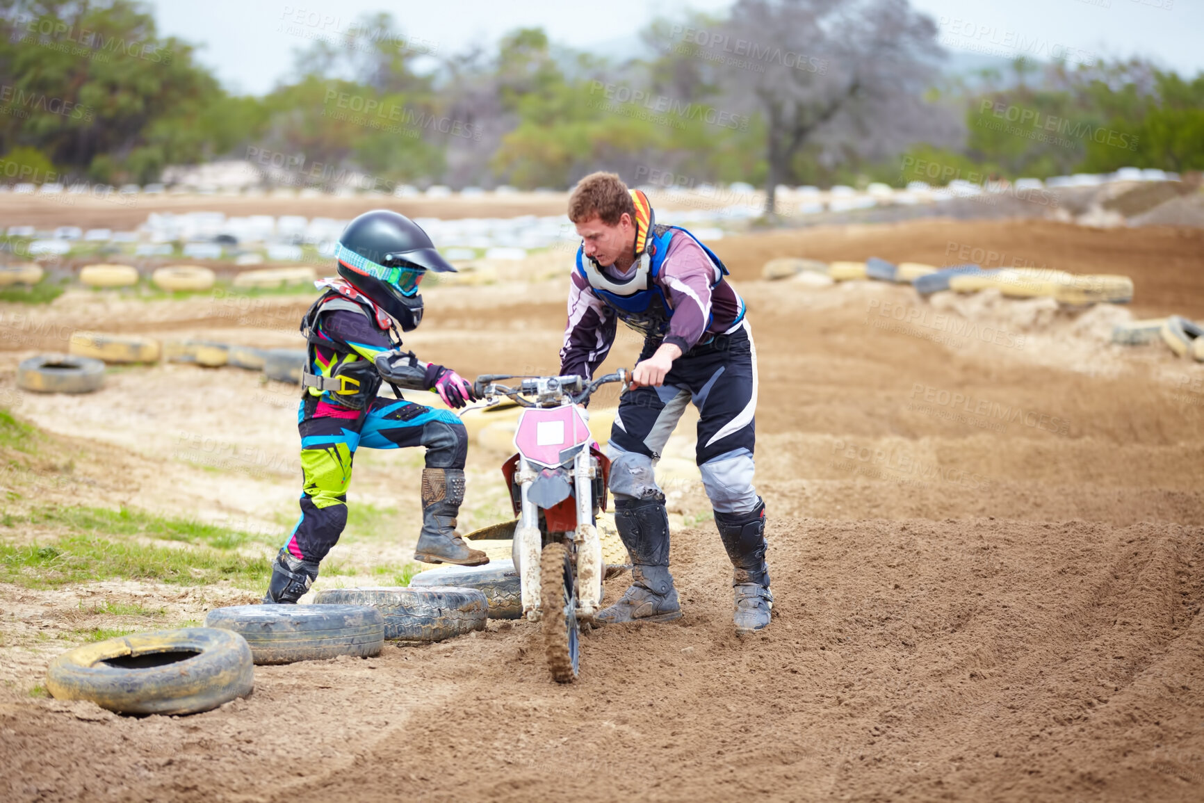 Buy stock photo Motorcycle, child and father help on dirt road, training and outdoor sports. Bike, kid and dad coaching rider, teaching and learning together at race, competition and mentor support on transportation