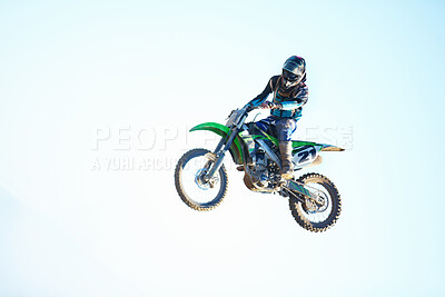 Buy stock photo Person, motorcycle and air stunt in blue sky as professional in action, competition or fearless. Bike rider, off road transportation jump or fast speed adventure at rally, outdoor challenge or race